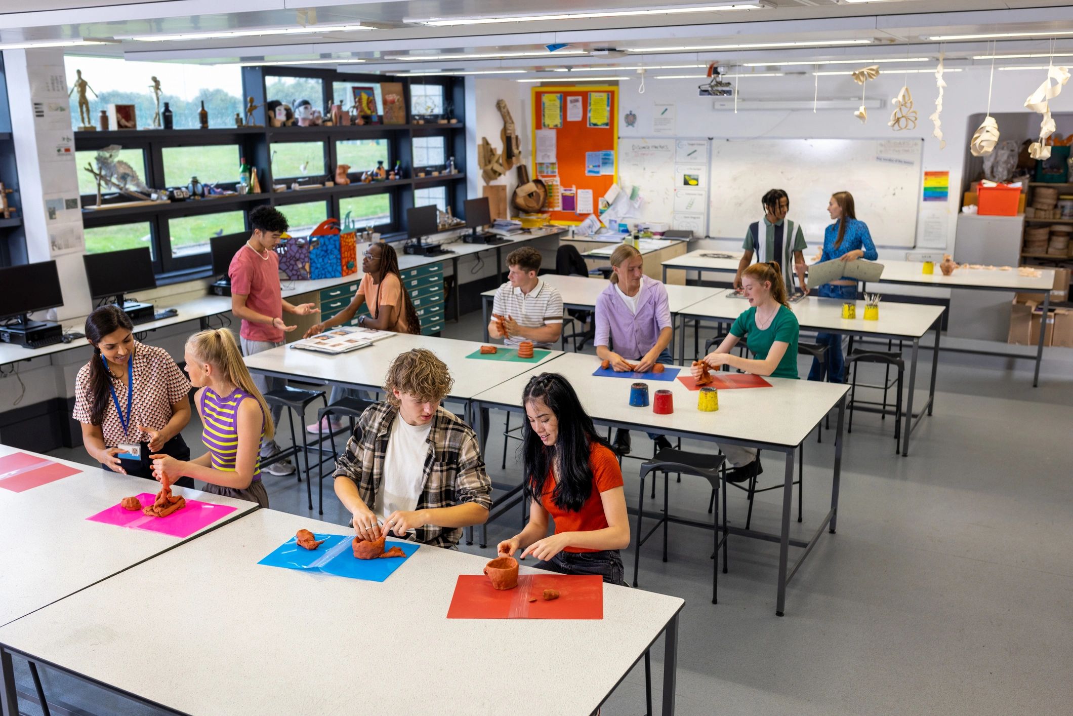 Teacher guiding students during a hands-on classroom activity